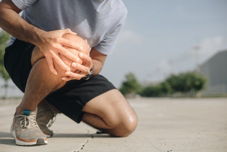 Young man suffering from knee pain outdoor