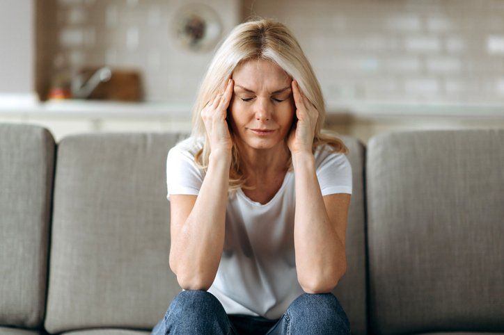 Middle-aged blonde woman with a headache
