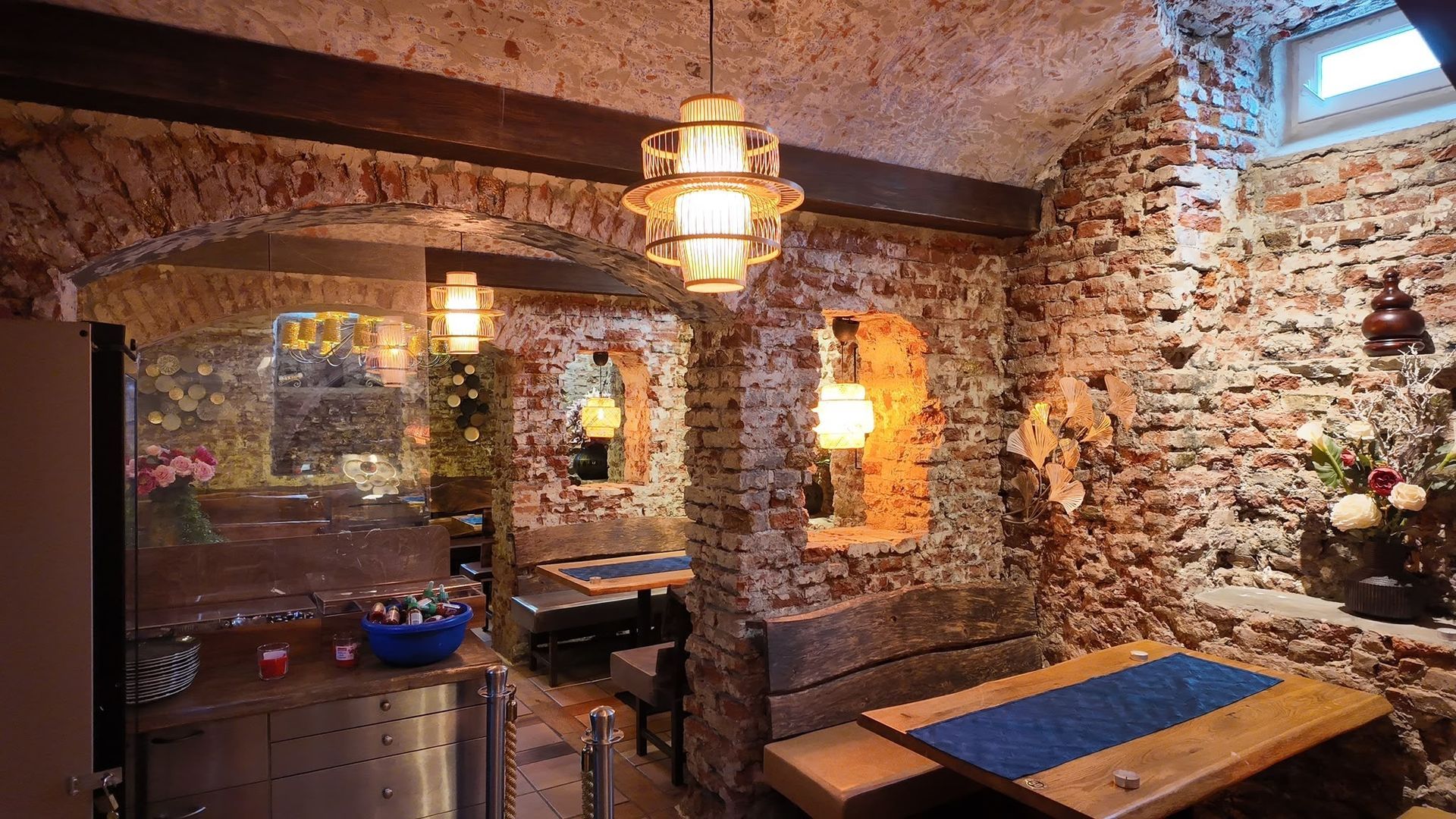 Gemütliches Esszimmer im Landhausstil mit Steinwänden, Hängelaternen und einem Holztisch neben einem Spiegel
