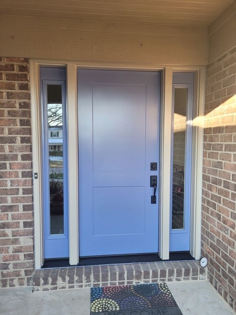 Blue front door with sidelights, cream trim, brick exterior.