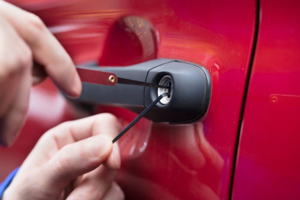 Close-up Of A Hand Lockpicking A Locked Car Door — Locksmith In Bendigo, VIC Close-up Of A Hand Lockpicking A Locked Car Door — Locksmith In Bendigo, VIC