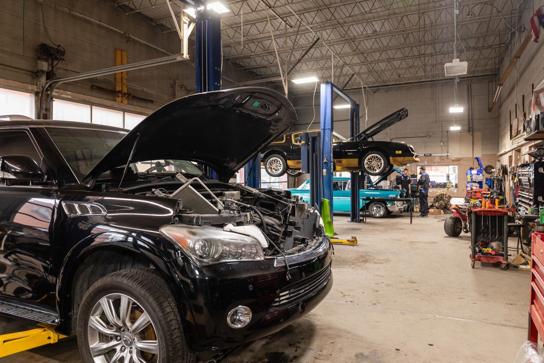 A Black SUV Is Sitting on a Lift in a Garage With Its Hood Open | Professional Auto Repair