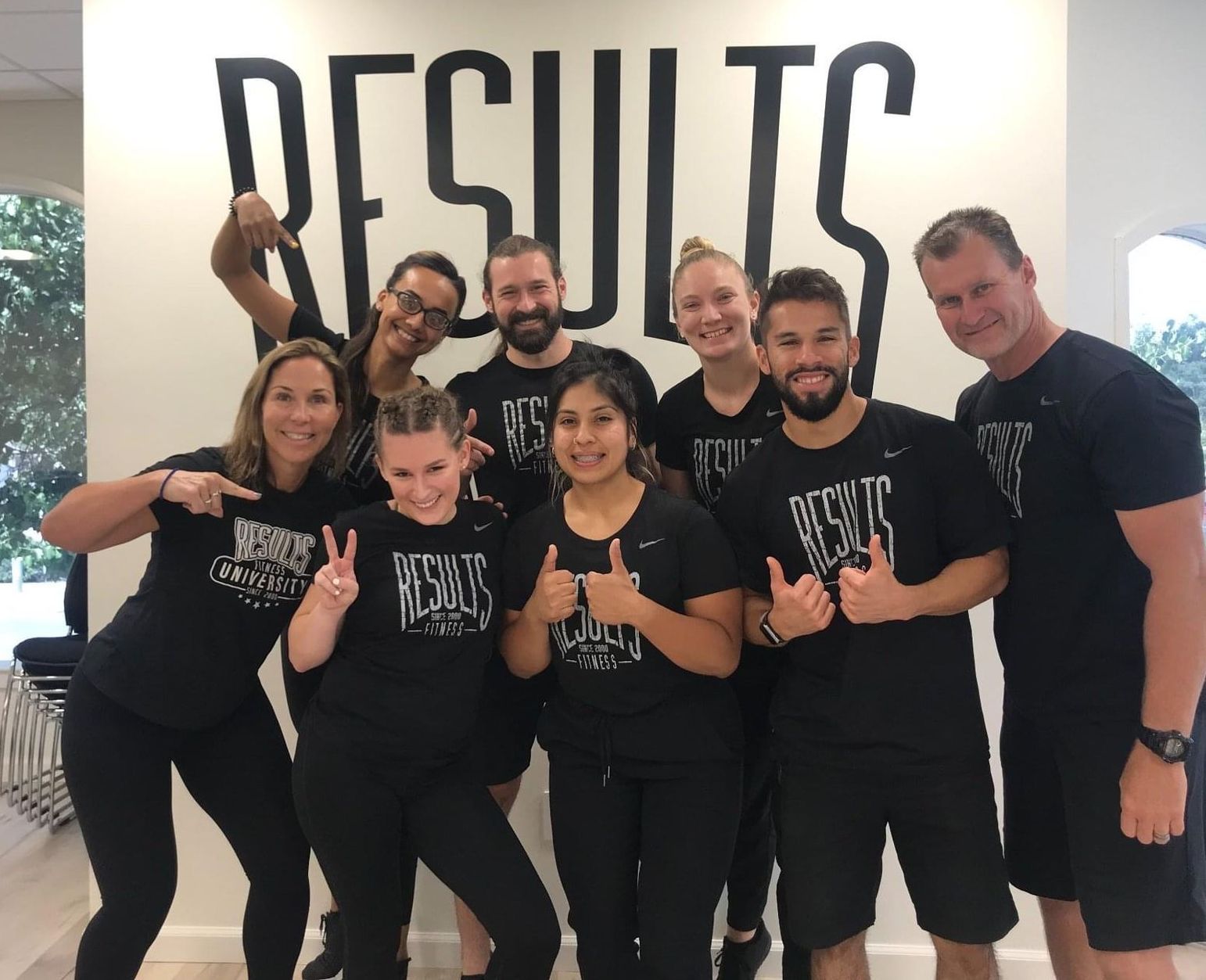 Group of eight people wearing black shirts with the word 