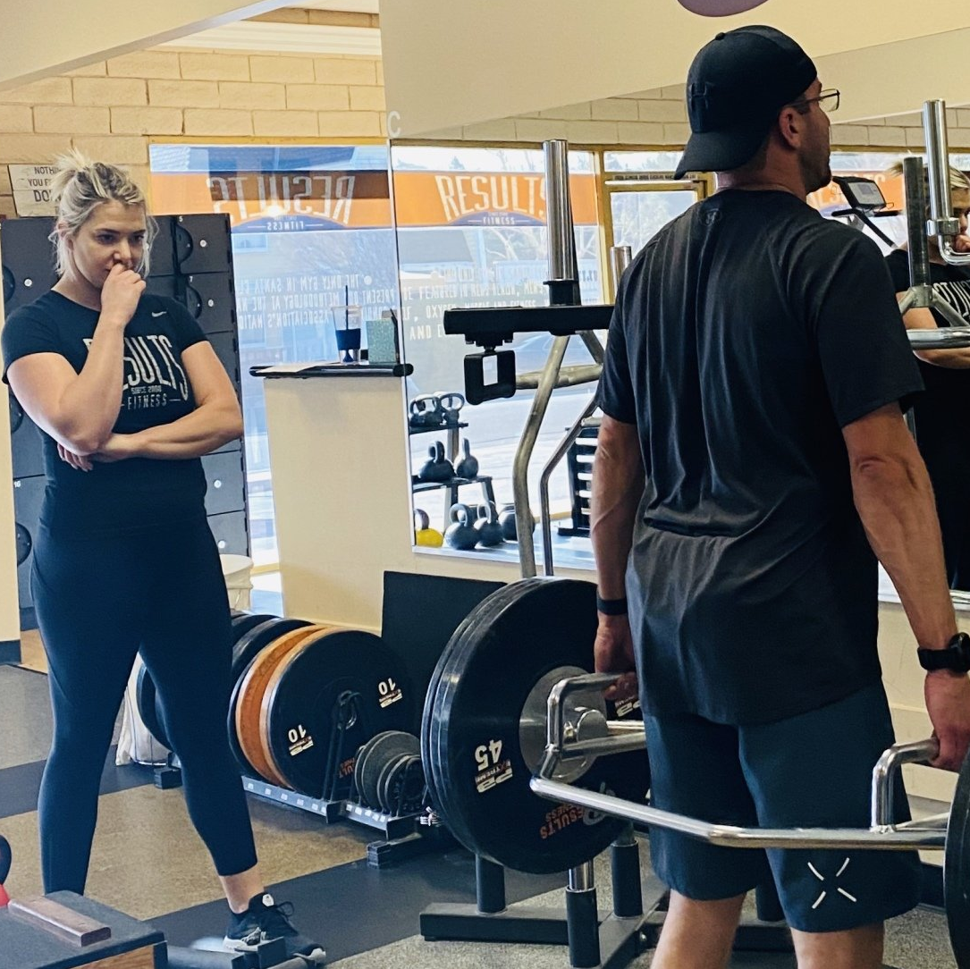 man doing deadlifts with a results fitness coach