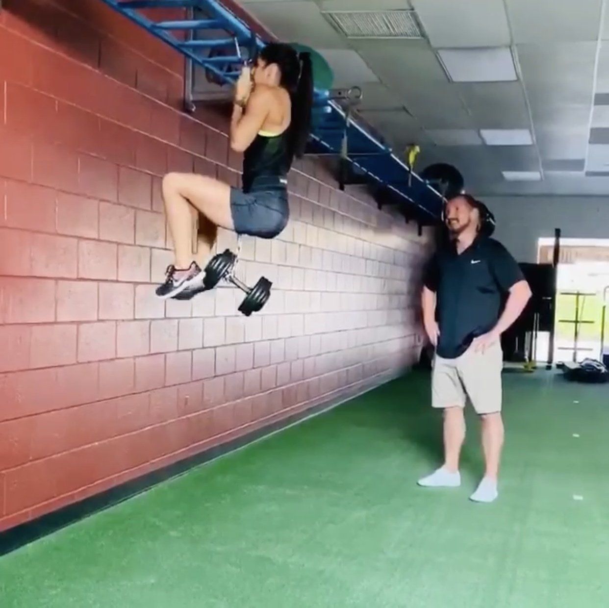 woman doing chin-ups with a dumbbell