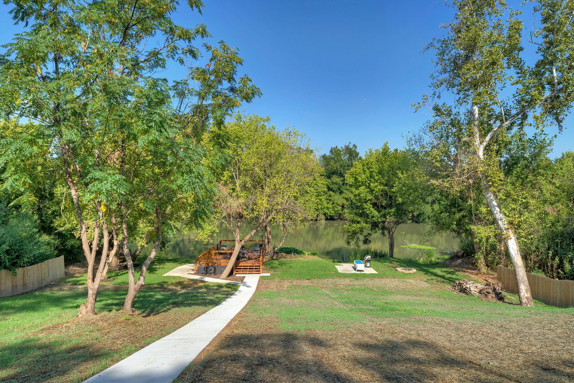 A path leading to a picnic area in a park surrounded by trees.