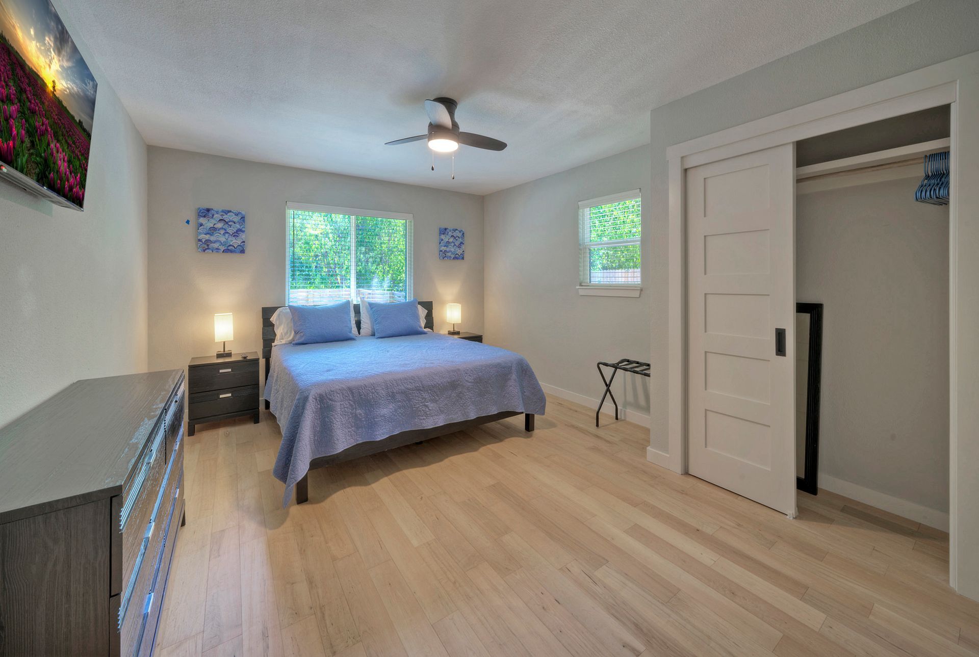 A bedroom with a king size bed , a dresser , and a ceiling fan.