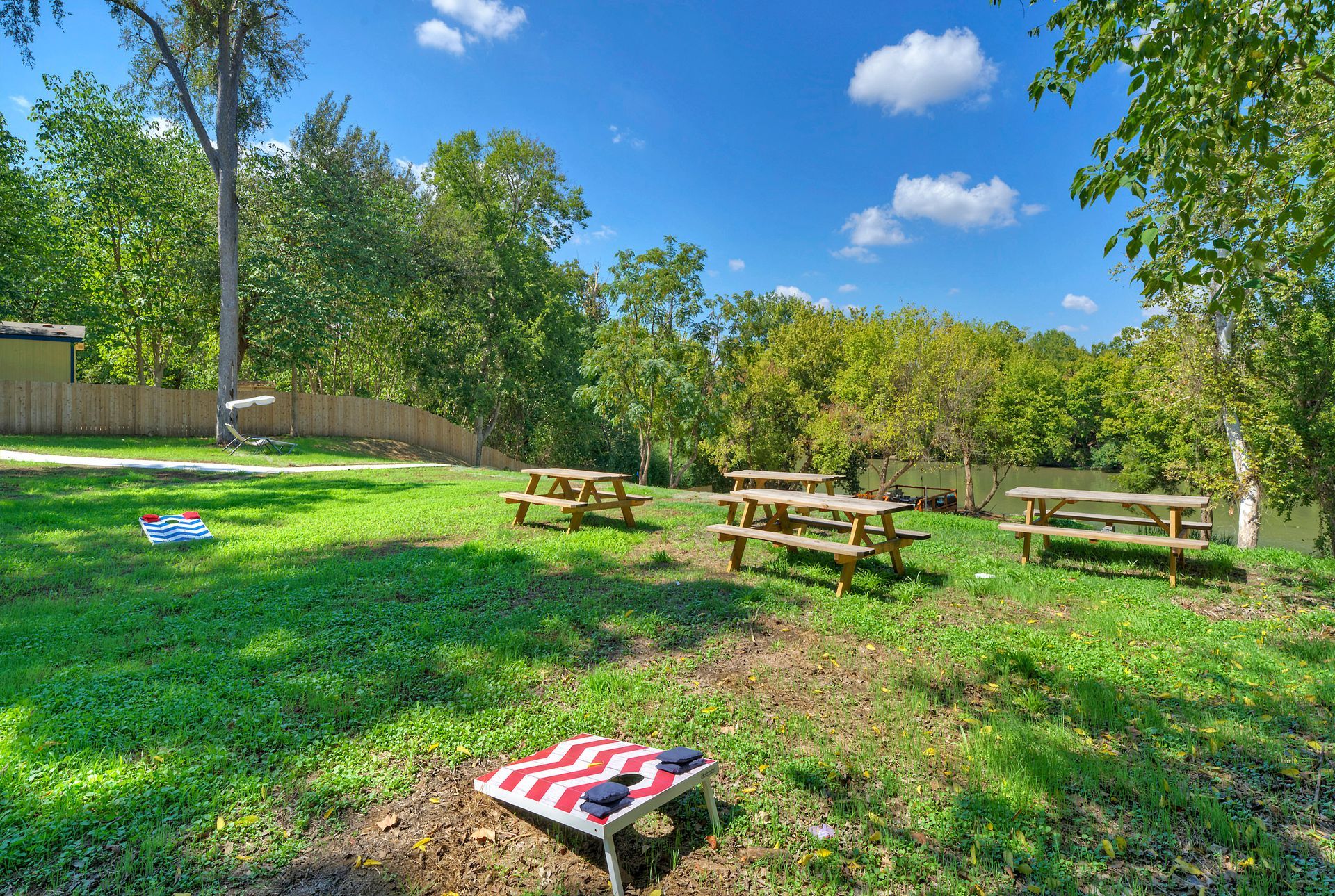 A group of picnic tables are sitting on top of a lush green field.