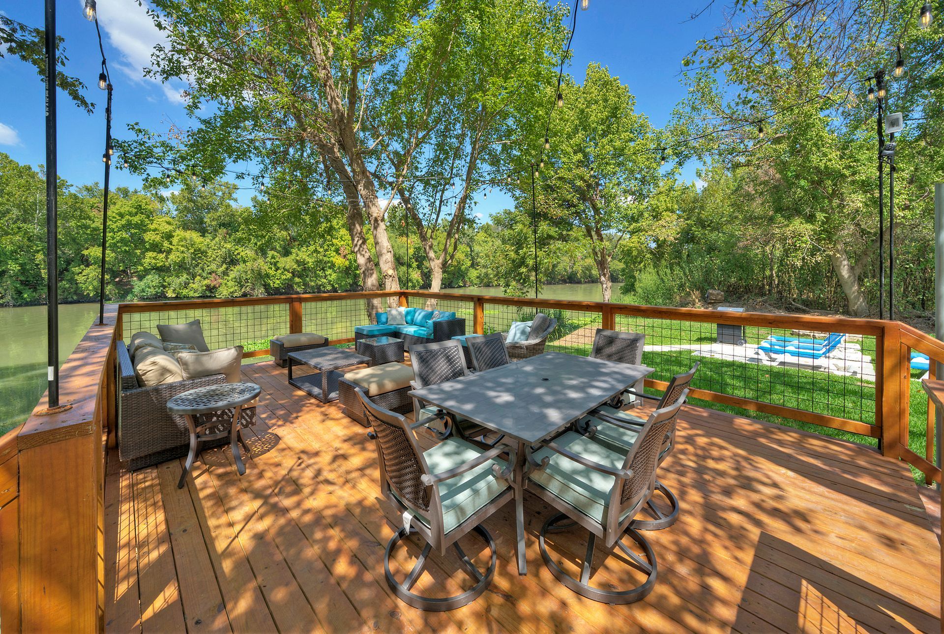 A large wooden deck with a table and chairs on it.