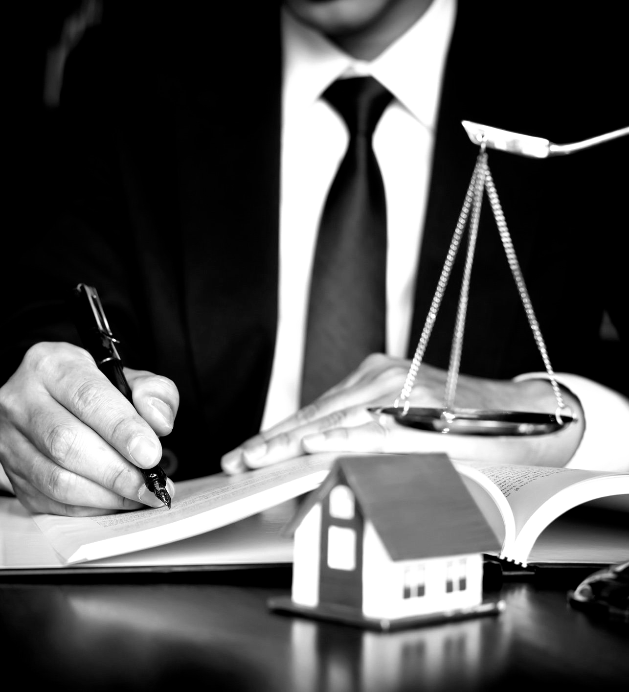 A man in a suit and tie is writing on a piece of paper. A man in a suit and tie is writing on a piece of paper