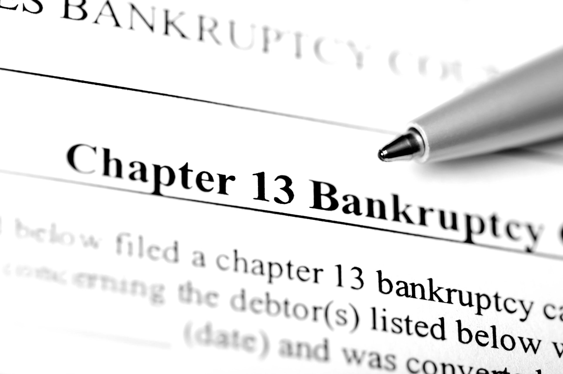 A pen is on a piece of paper that says chapter 13 bankruptcy. A pen is on a piece of paper that says chapter 13 bankruptcy.