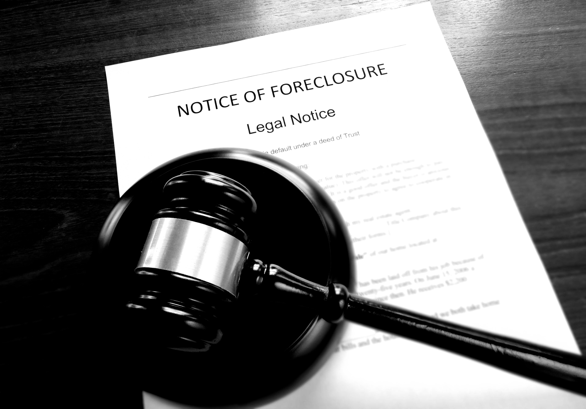 A judge 's gavel sits in front of a notice of forclosure. A judge 's gavel sits in front of a notice of forclosure.