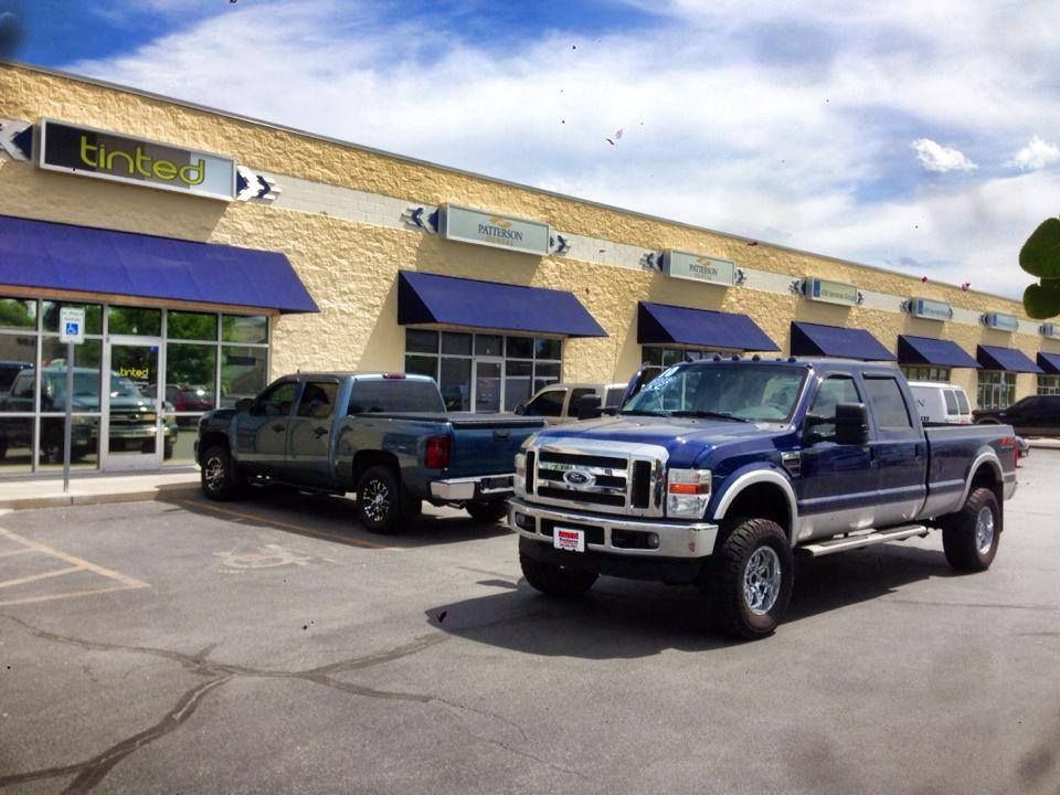 A blue truck is parked in front of a building that says brake