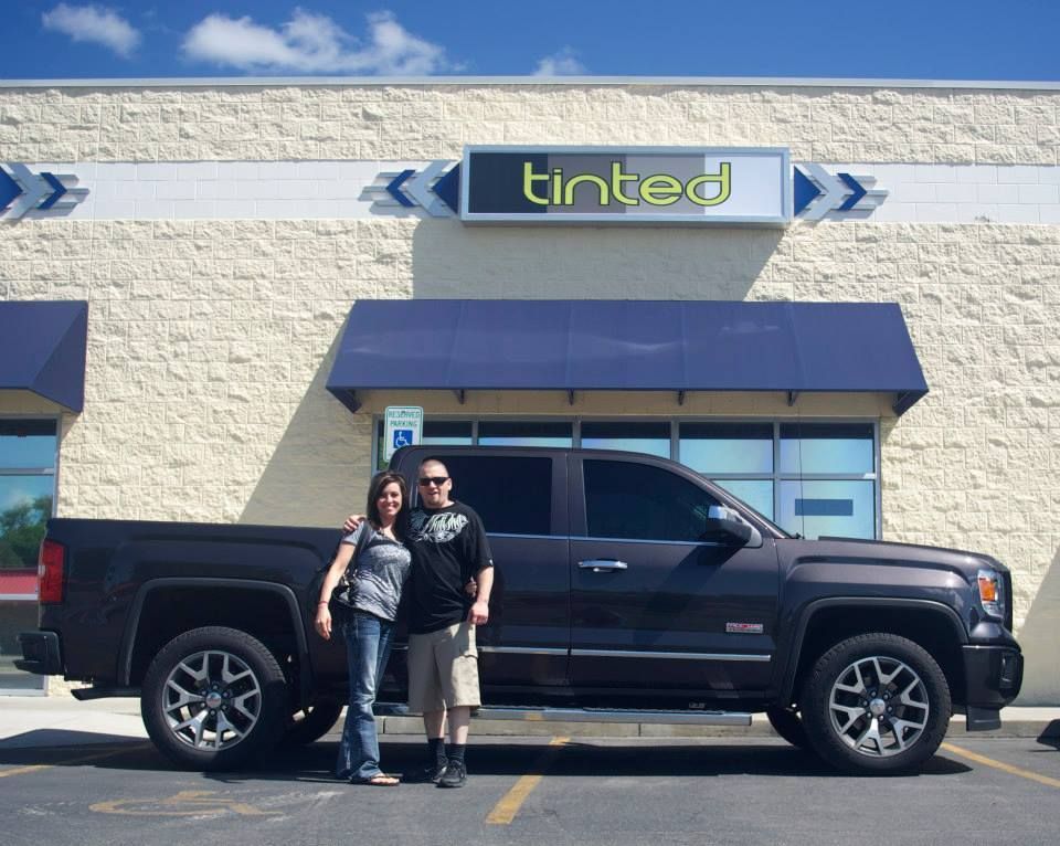 A couple standing in front of a tinted truck
