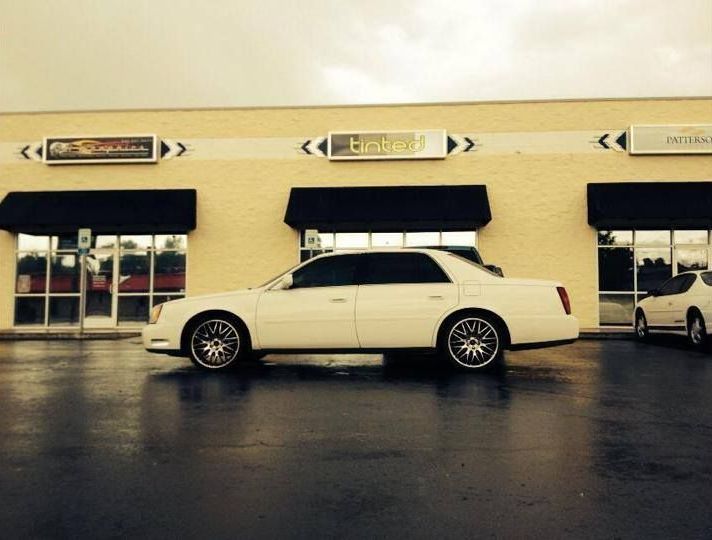 A white car is parked in front of a building