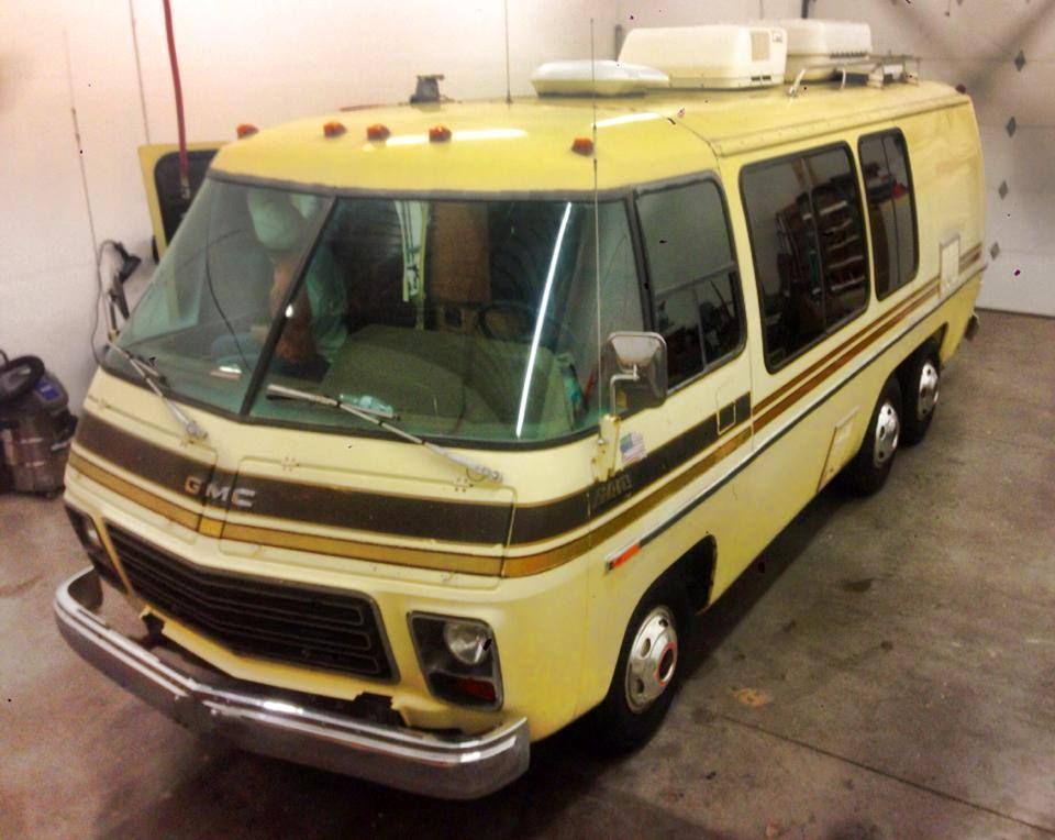 A yellow gmc van is parked in a garage