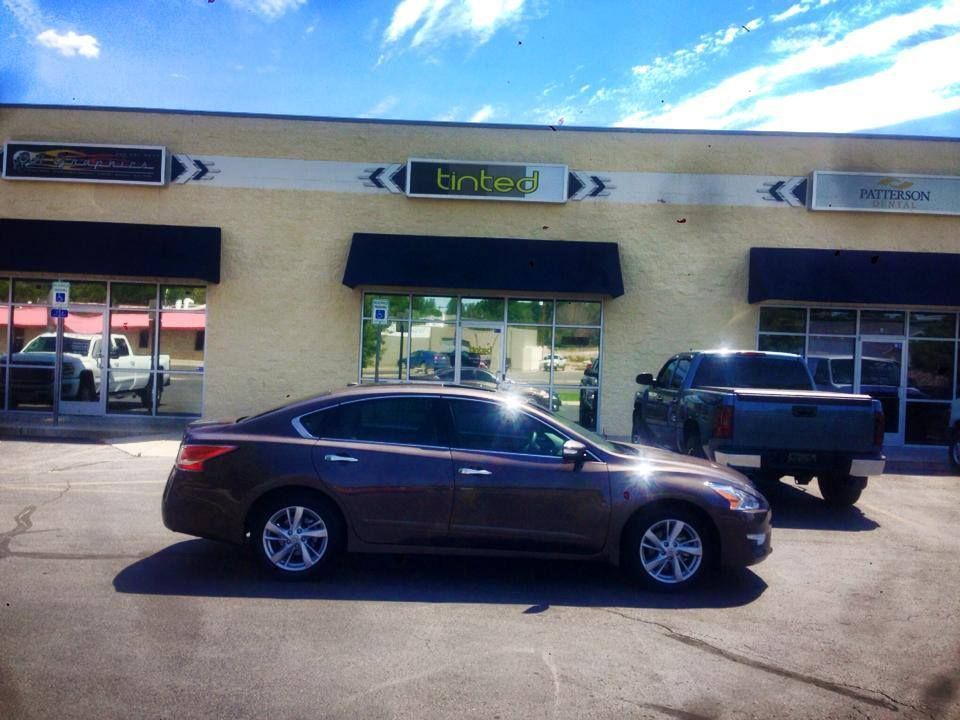 A car is parked in front of a building that says trident