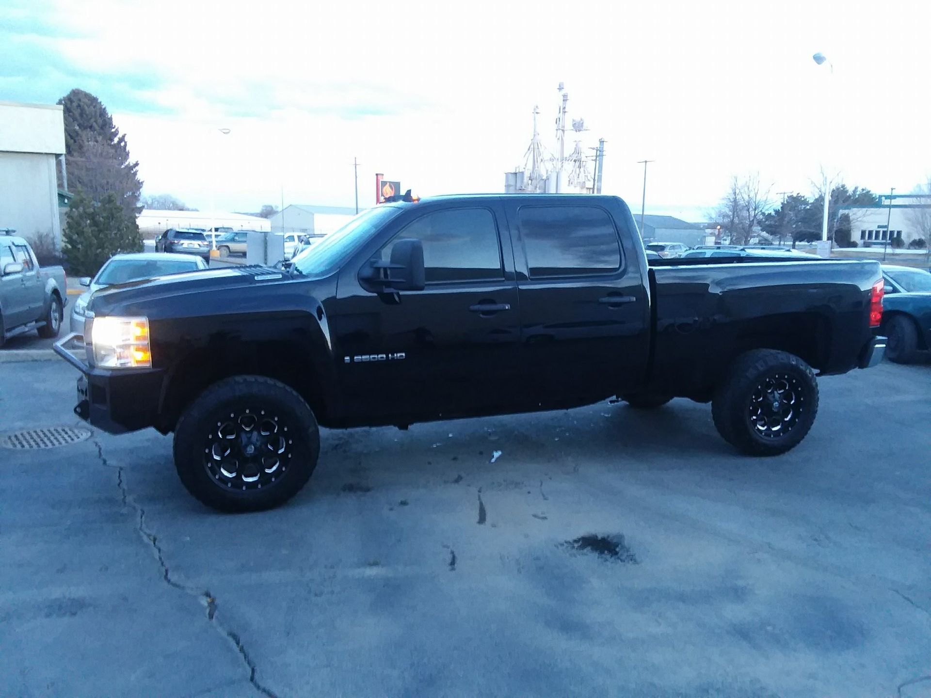 A black truck is parked in a parking lot.