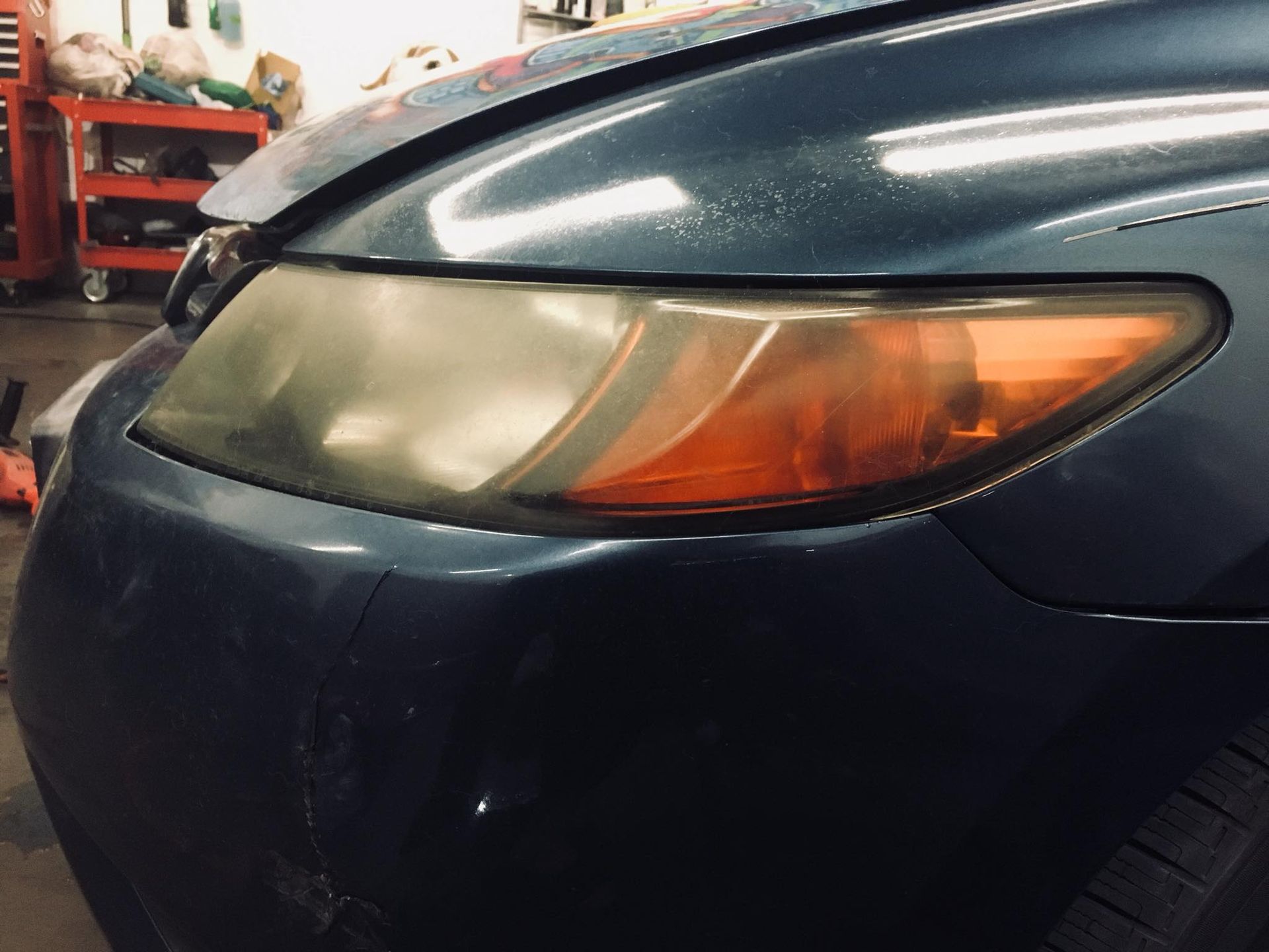 A close up of a car 's headlight in a garage