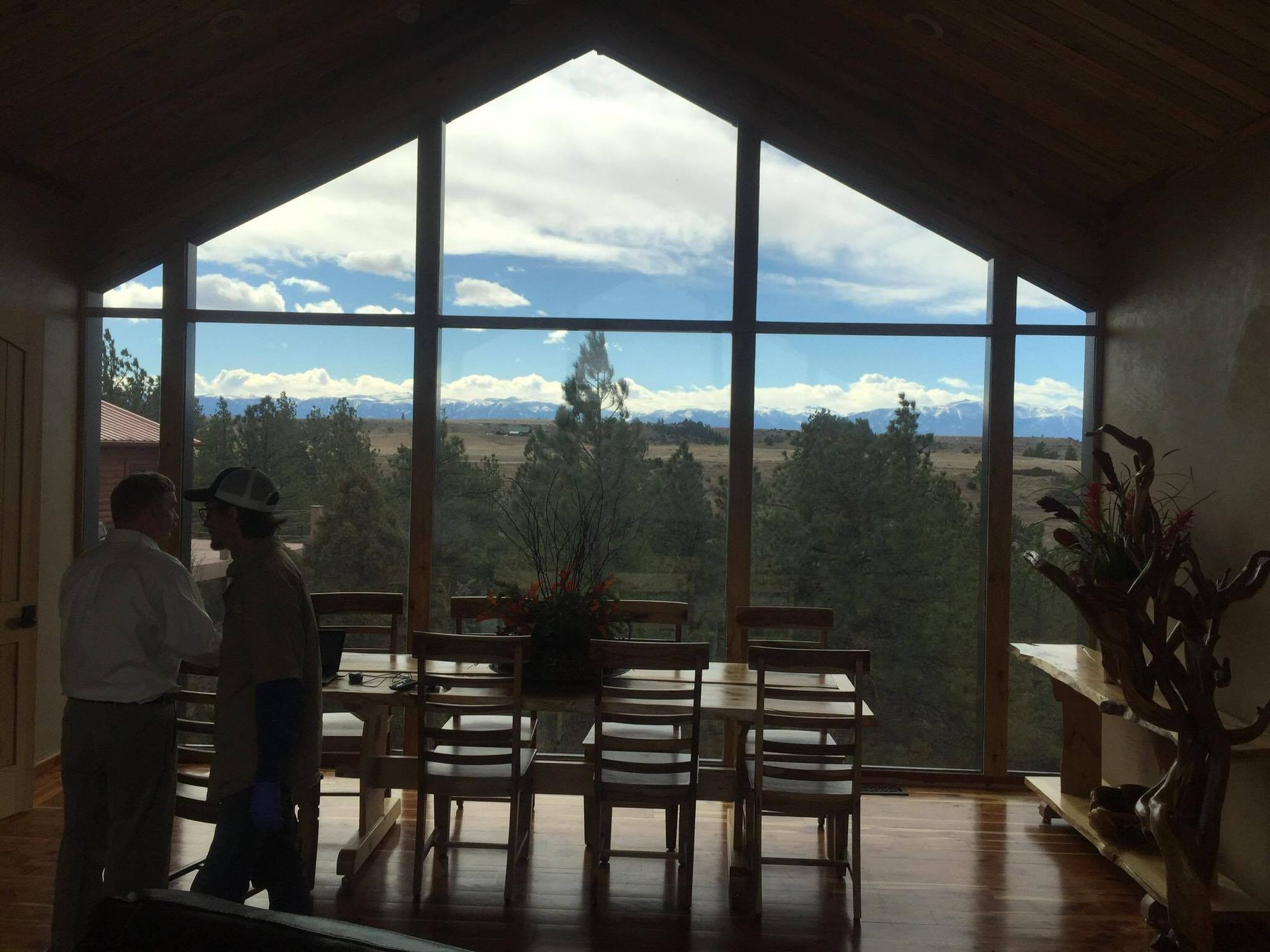 A couple of people standing in front of a large window
