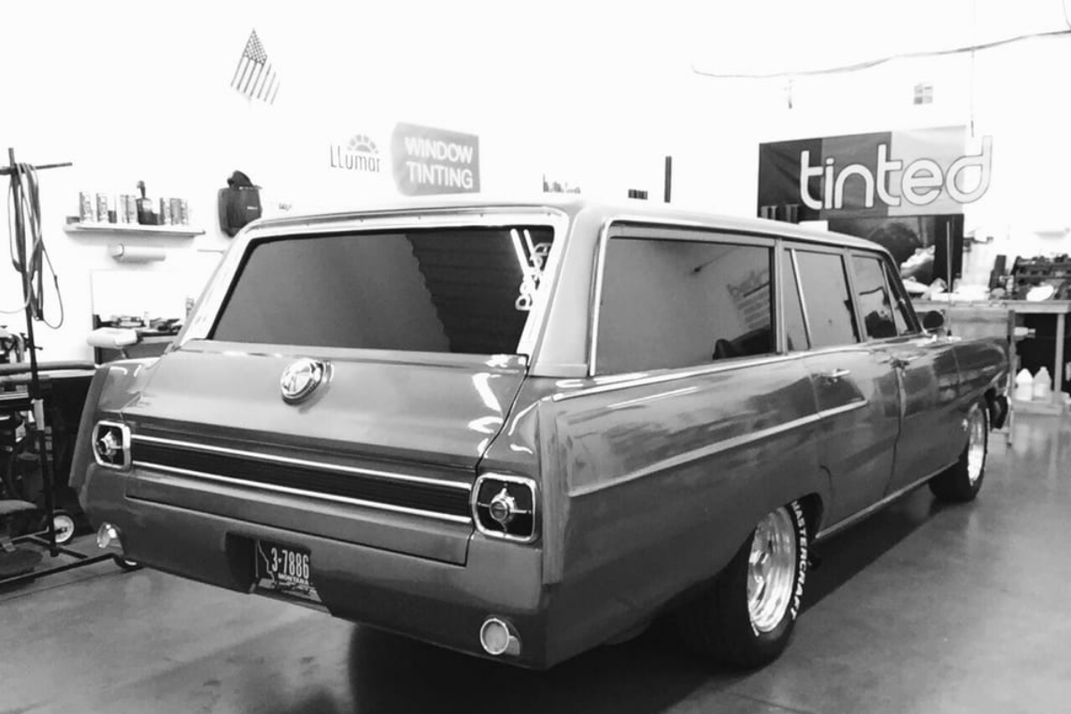 A black and white photo of a station wagon with tinted windows