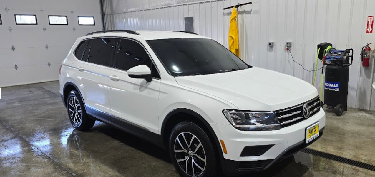 A white volkswagen tiguan is parked in a garage.