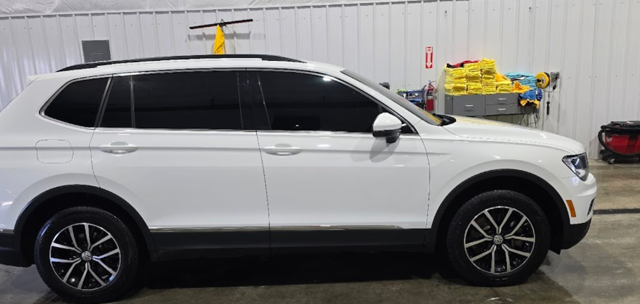 A white volkswagen tiguan is parked in a garage.