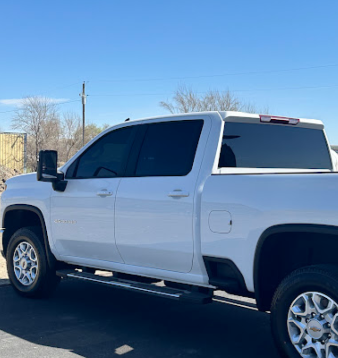 A white truck is parked in a parking lot on a sunny day.
