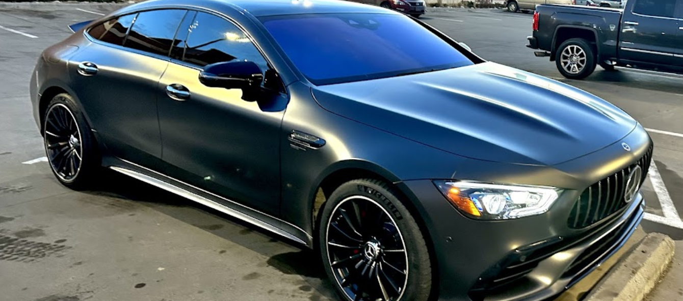 A black mercedes benz amg gt 63 s is parked in a parking lot.