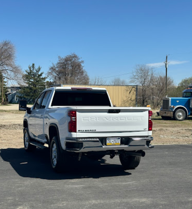 A white chevrolet truck is parked on the side of the road