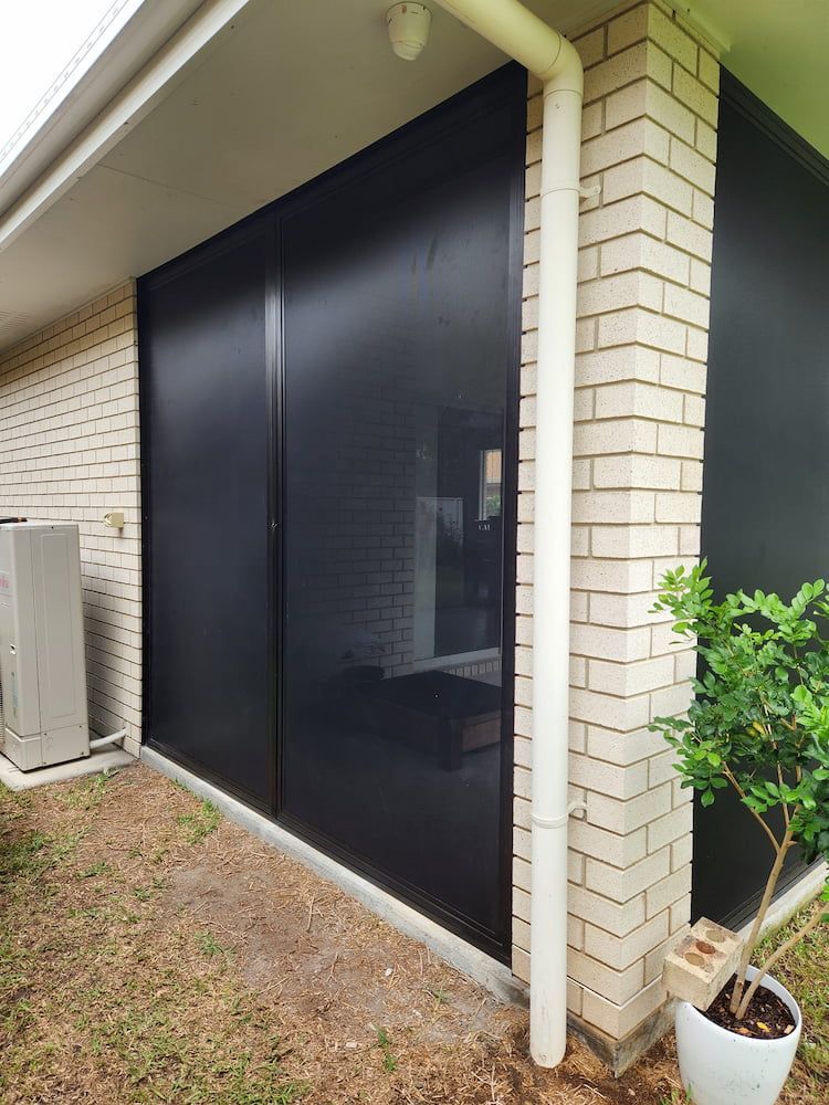 A Brick House With a Patio Enclosure and a Potted Plant — Smart Screens Qld in Ormeau, QLD