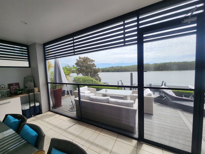 Modern Living Room Opening to A Lake View Balcony — Smart Screens Qld in Ormeau, QLD