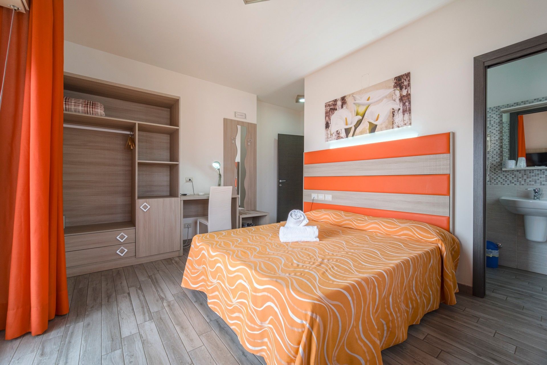 Una camera d'albergo con un letto grande e un bagno.