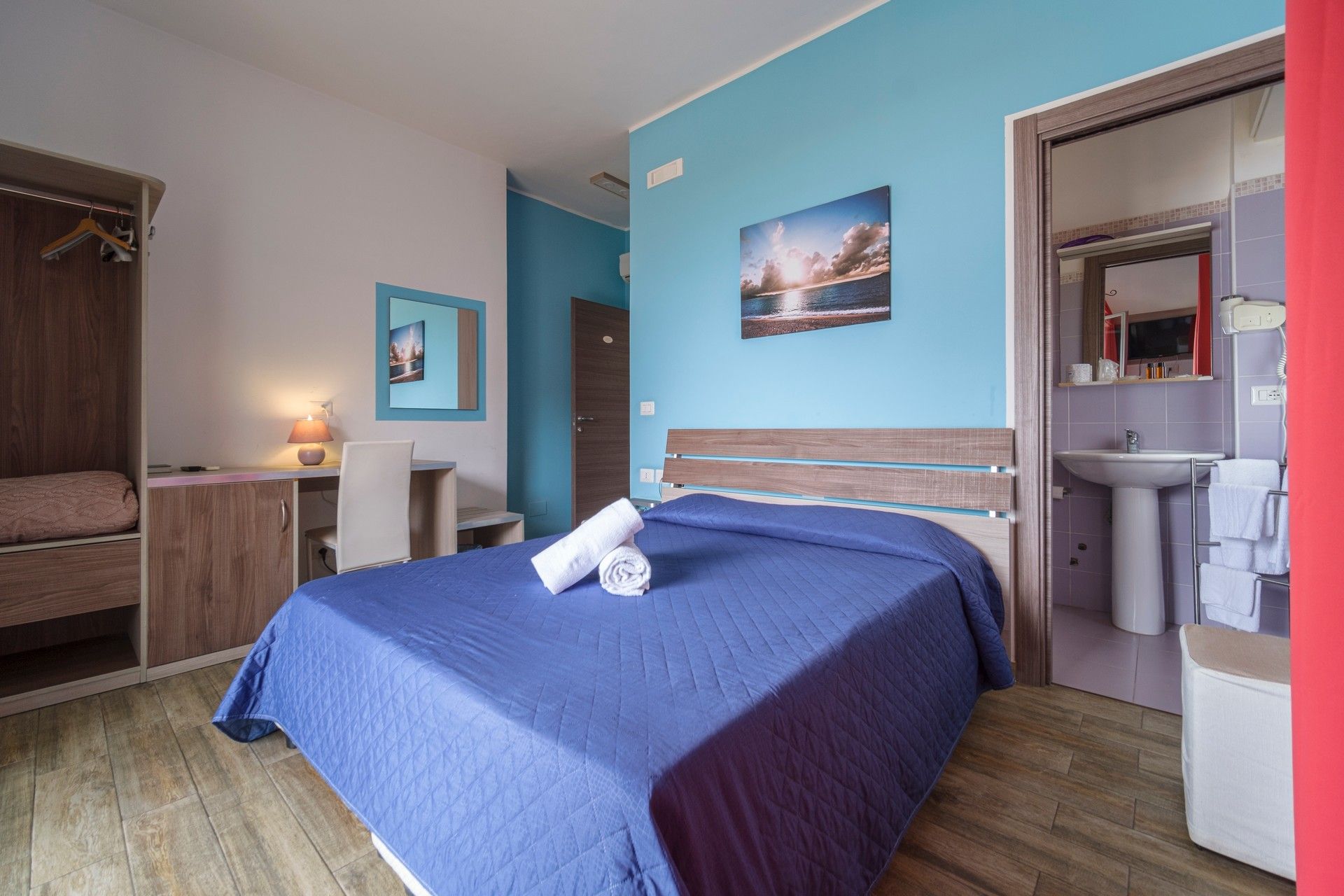 Una camera d'albergo con un letto grande e un bagno.