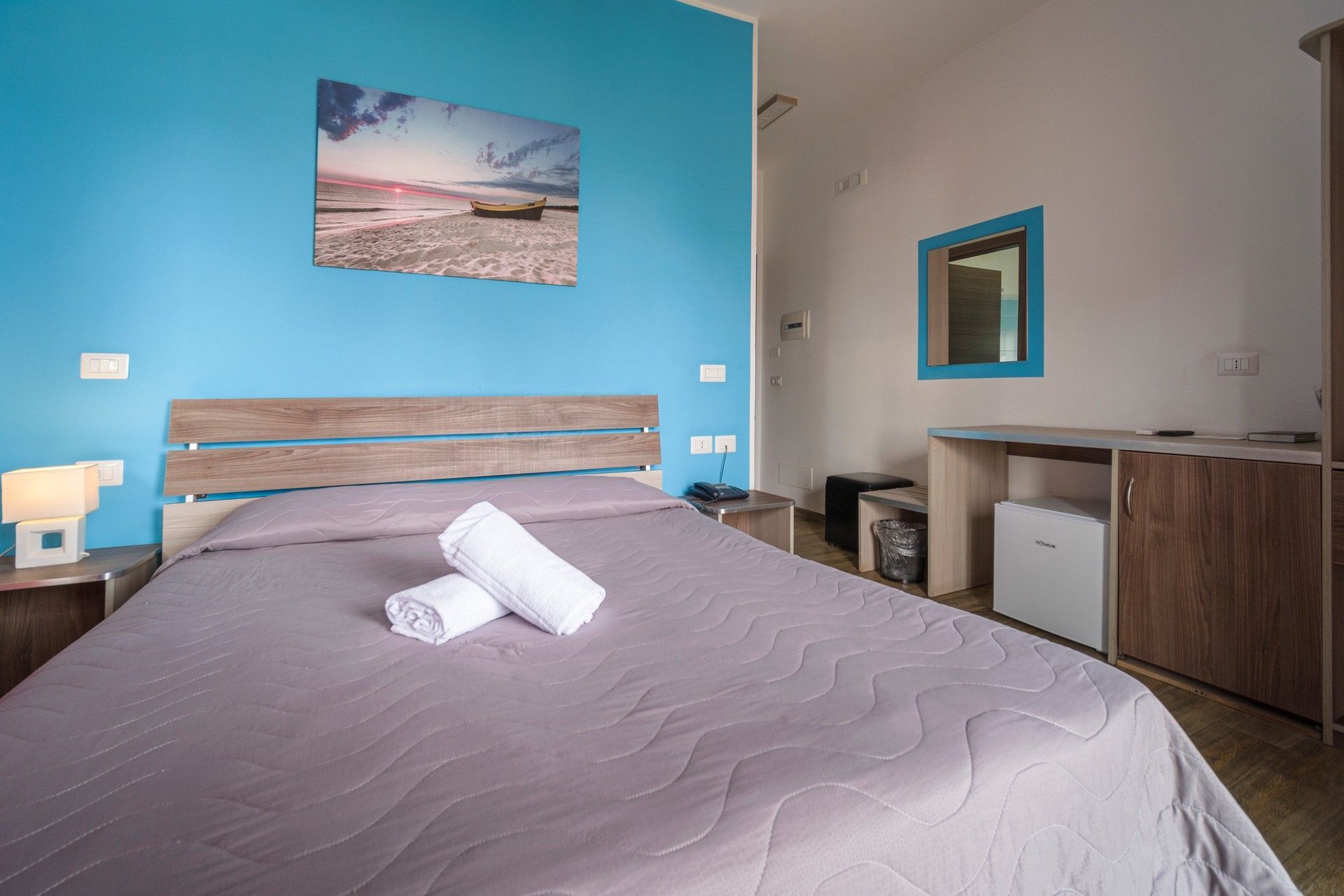 Una camera da letto con un letto e una parete blu.