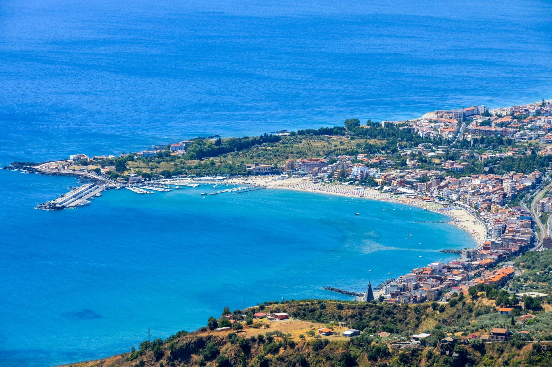 Una veduta aerea di una piccola città sulla riva di un grande specchio d'acqua.