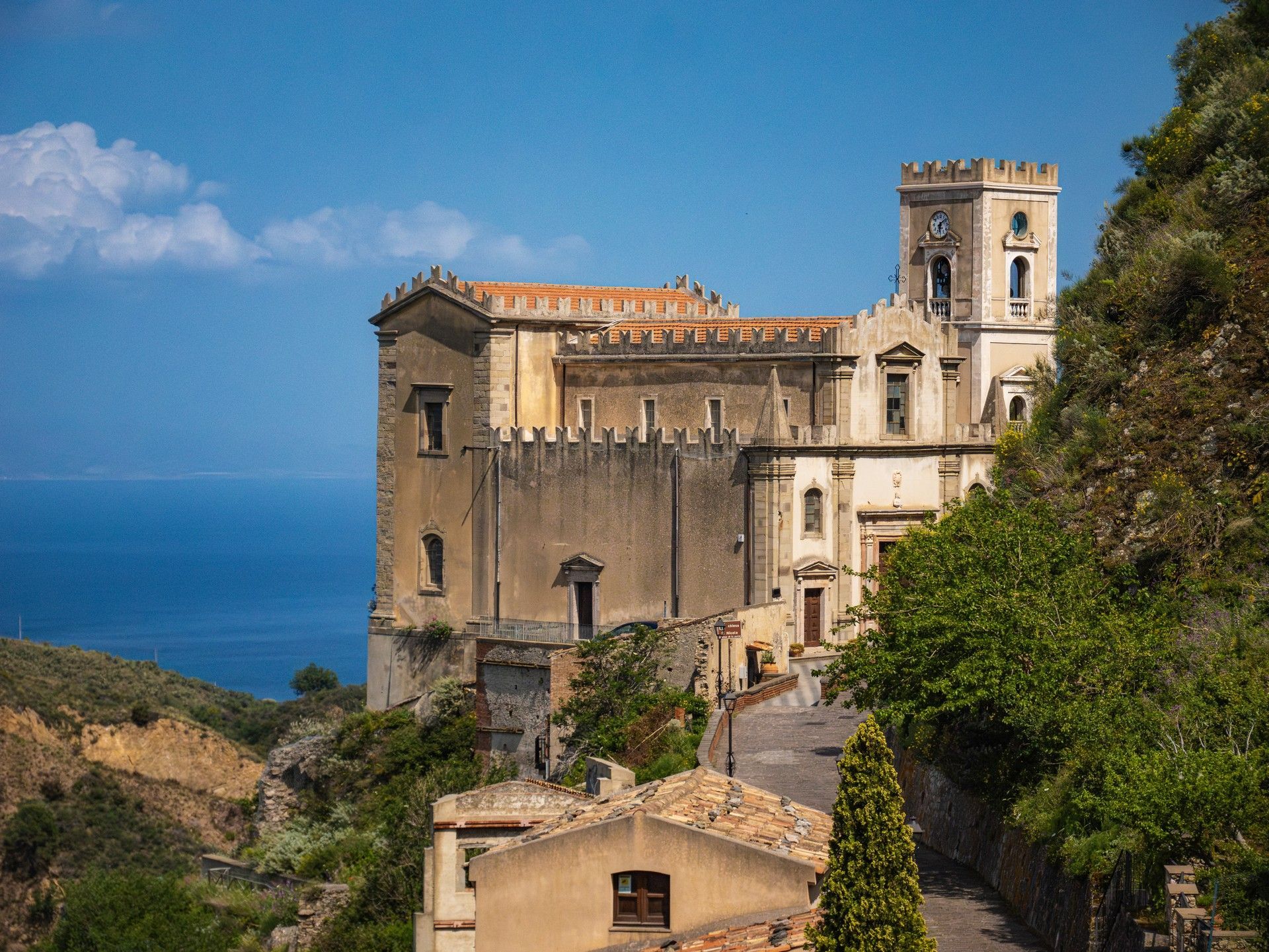 Un grande edificio è situato in cima ad una collina che domina l'oceano.