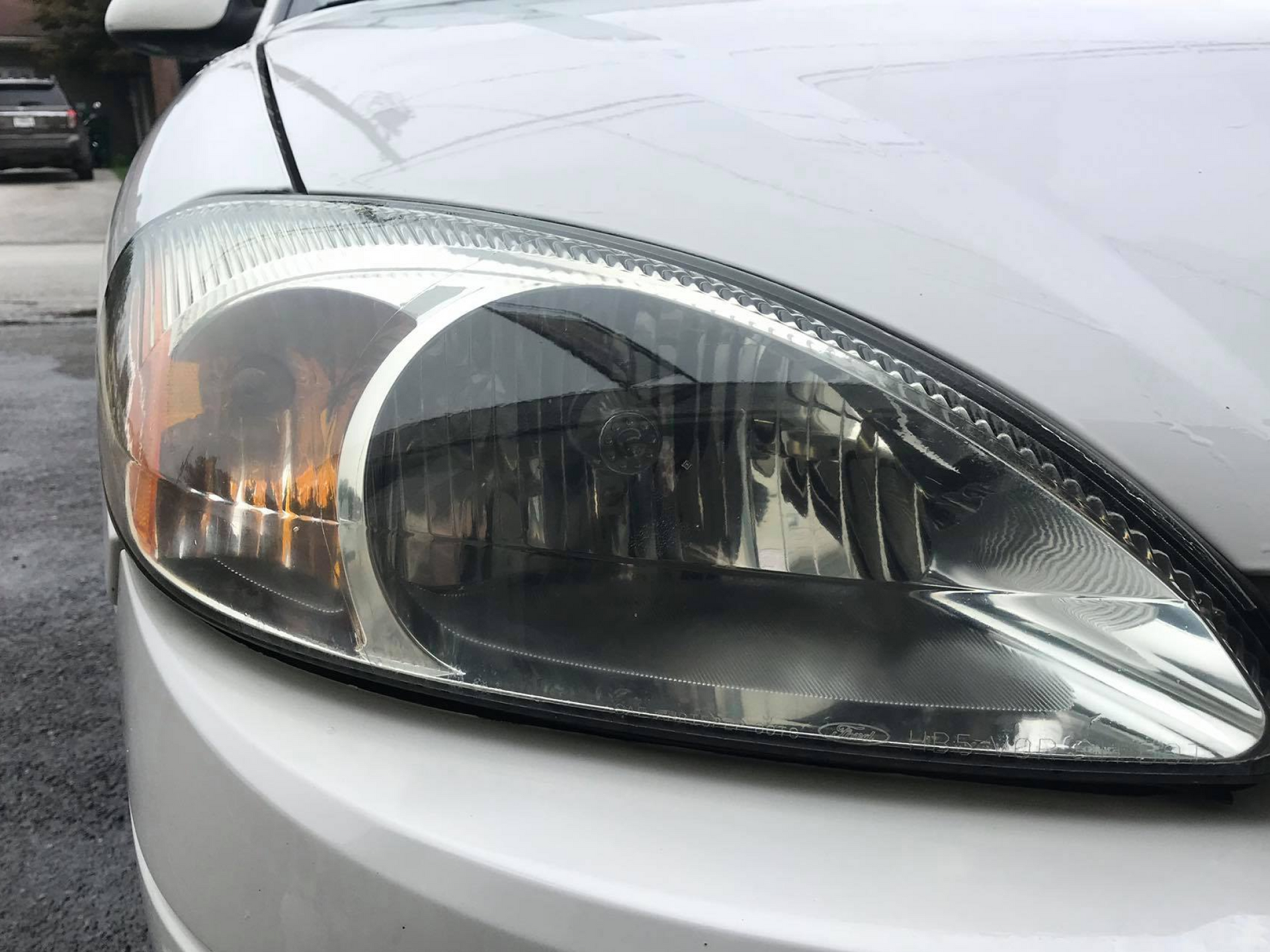 a close up of a white car 's headlight .