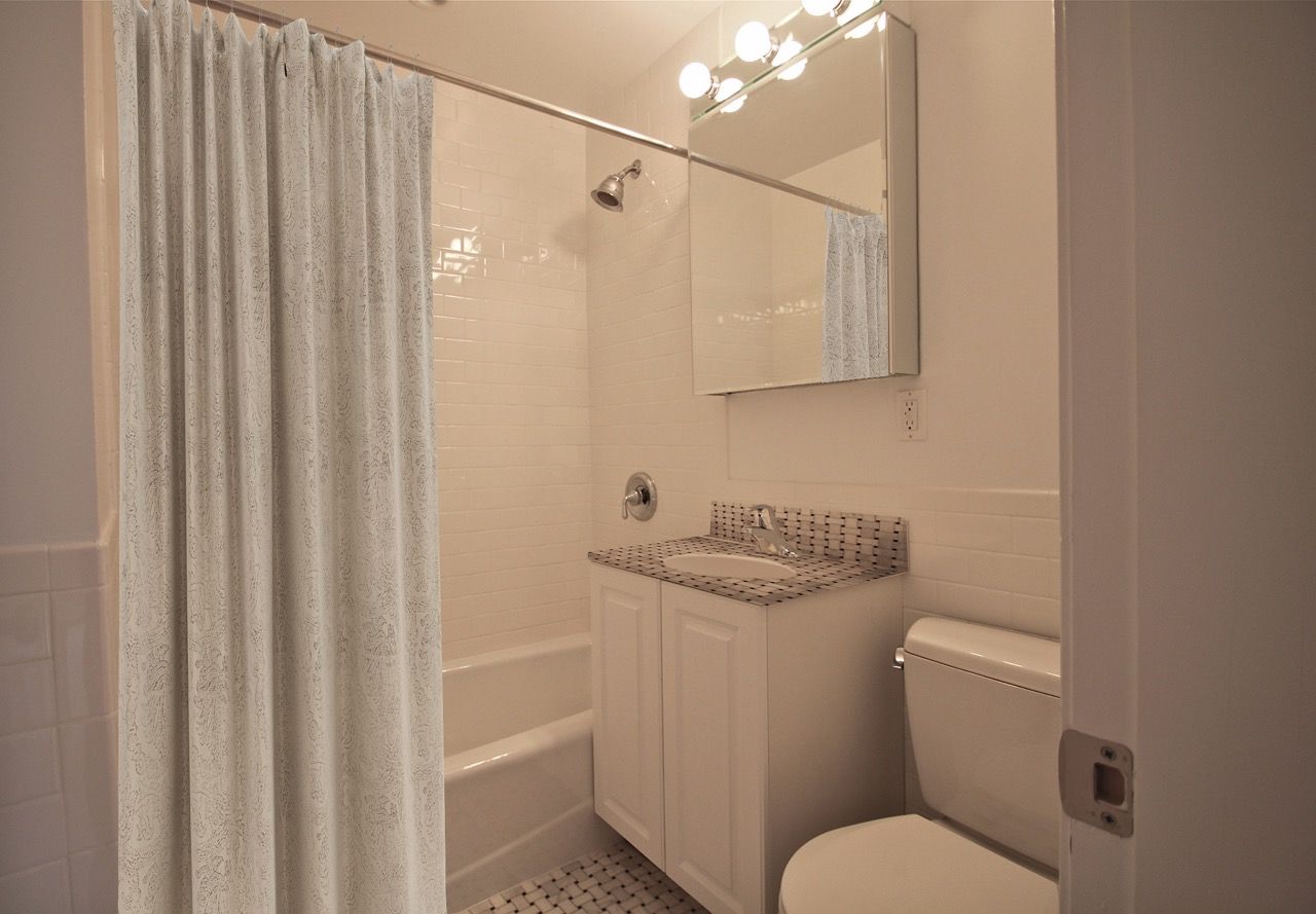 Bathroom in an apartment with tub/shower, vanity, and toilet.