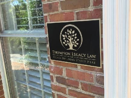 Black sign on brick: 