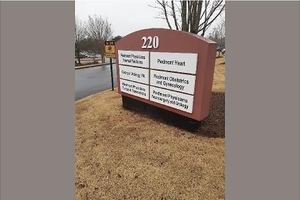 Sign for building 220 with business names: Medical, Pediatric, Ob/Gyn, and more; brown, white, and black sign.
