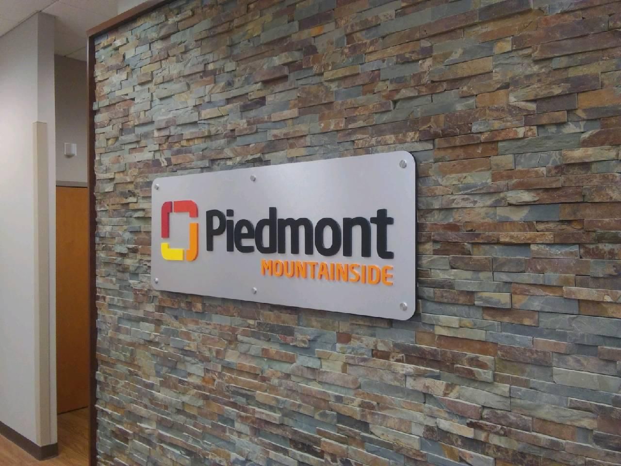 Piedmont Mountainside sign on a textured stone wall, in a building.