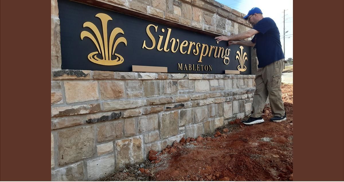 Man installing a sign that reads 