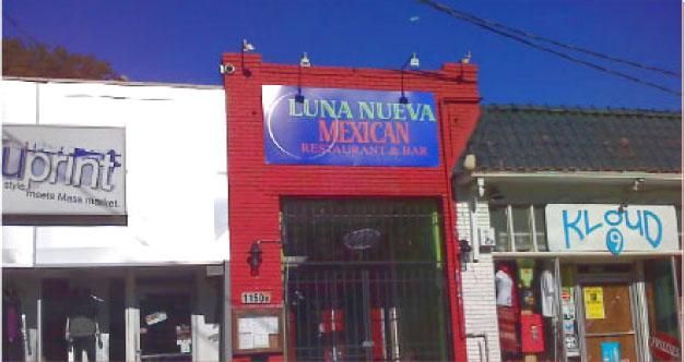 Luna Nueva Mexican Restaurant with red facade and blue sign between other storefronts.