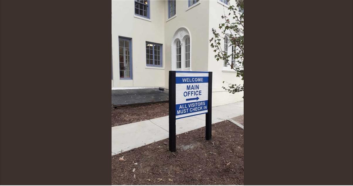 Sign for Main Office in front of a light building.