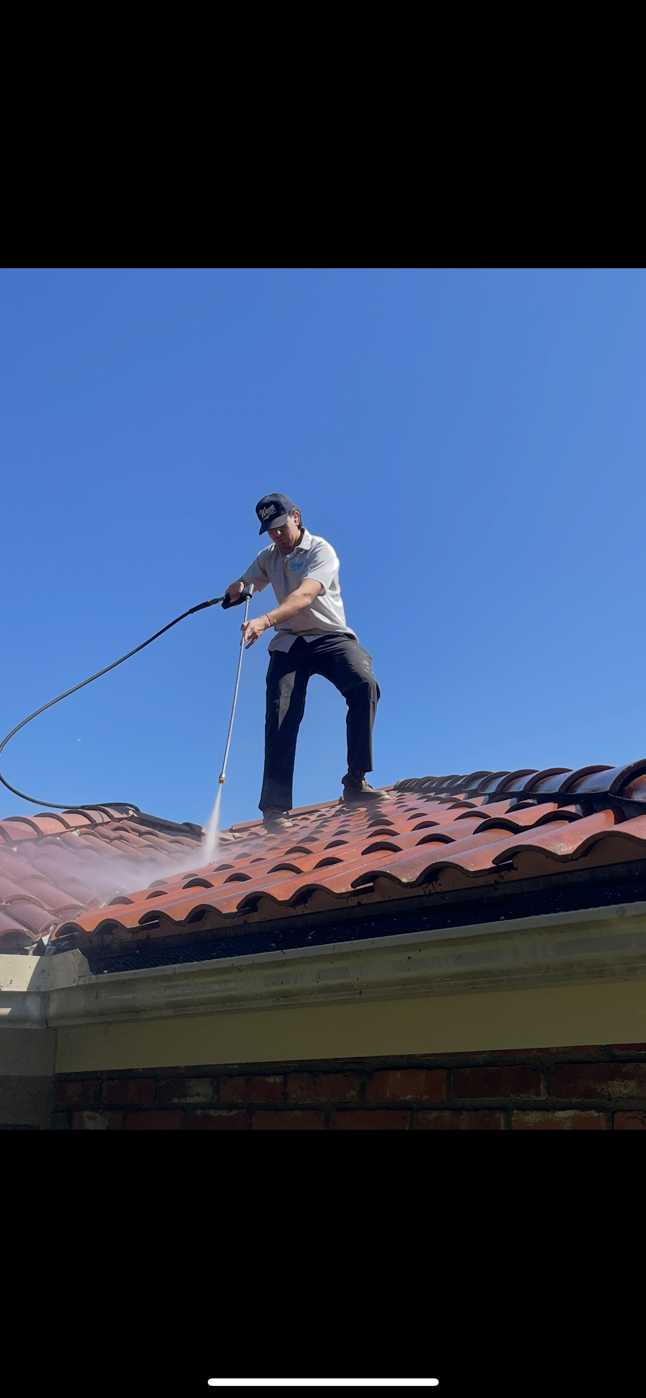 Pressure washing a wooden deck, removing dirt from weathered boards