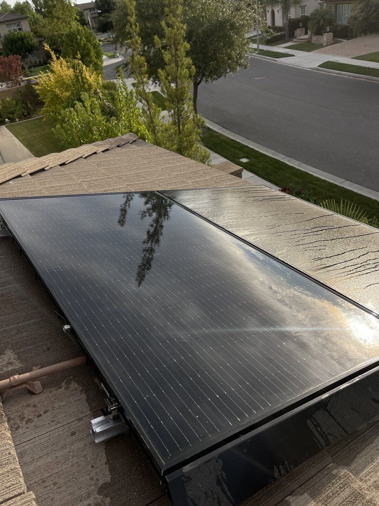 Solar panel installed on a residential rooftop beside a suburban street.