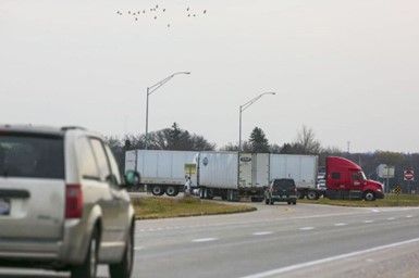 A truck is driving down a highway next to a van. A truck is driving down a highway next to a van.