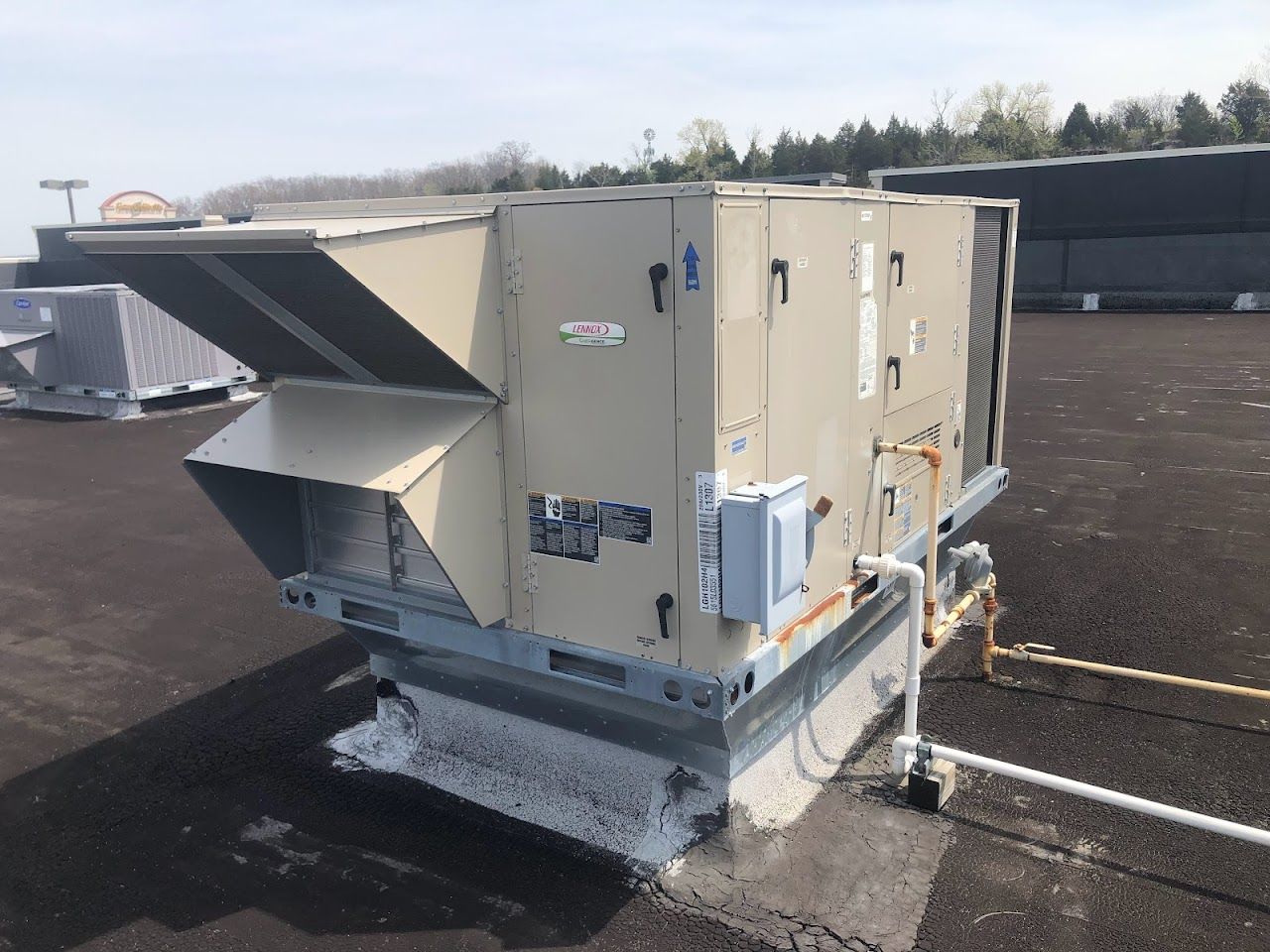 A large air conditioner is sitting on top of a roof.