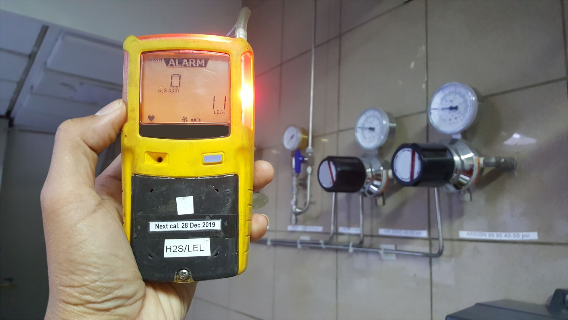 A person is holding a gas detector in their hand.